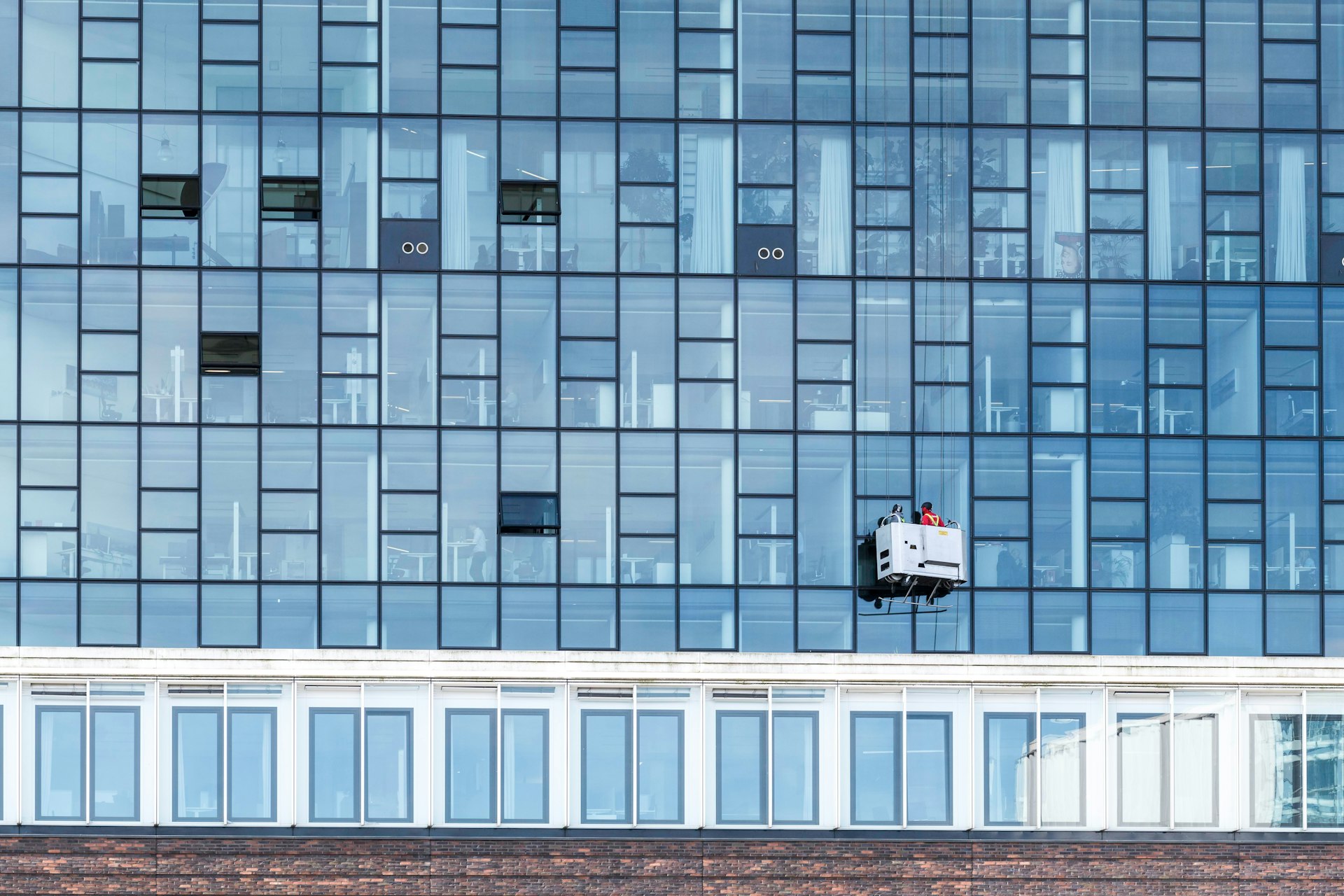 a window washer is hanging on the side of a building